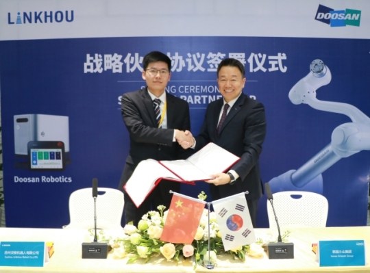 이병서 두산로보틱스 대표(오른쪽)와 동하우 링호우 대표가 중국 내 협동로봇 공급을 위한 대리점 계약서에 서명한 뒤 기념촬영을 하고 있다. 사진=두산로보틱스 제공
